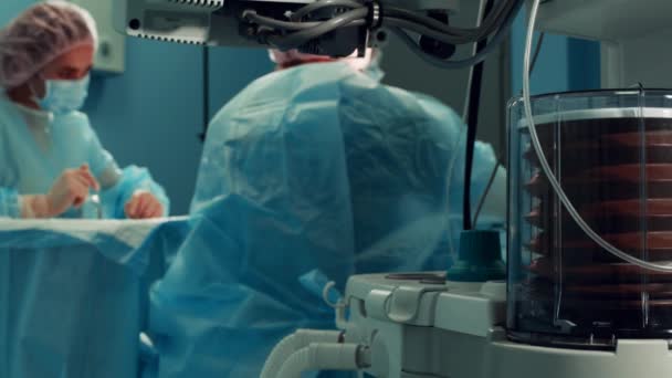 Nahaufnahme des Beatmungsgeräts der Anästhesie und der Patienten im Operationssaal. Nahaufnahme, verschwommener Hintergrund, blaues Licht. — Stockvideo
