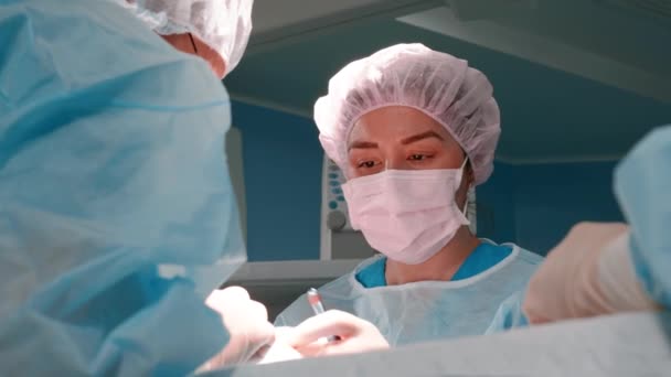 Cirugía plástica facial. Trabajo en equipo con la enfermera y el cirujano que realiza la cirugía en el hospital. Equipo médico realizando operación quirúrgica, blefaroplastia, rinoplastia — Vídeo de stock