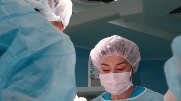 面部整形手术 与护士和在医院做手术的外科医生协同工作。 实施外科手术、眼睑成形术、鼻成形术的医疗队 — 图库视频影像