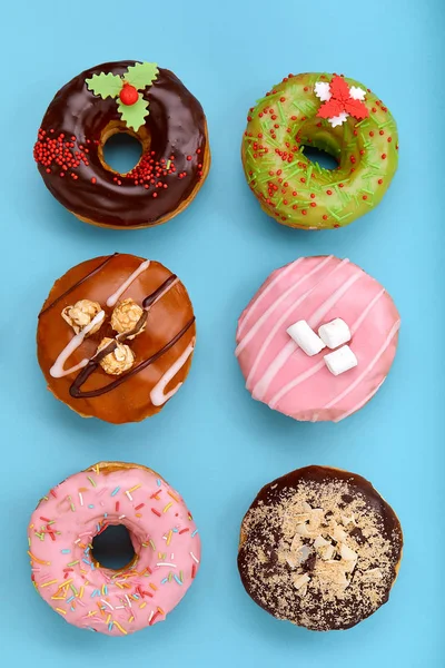 Various colorful donuts on blue background. Top view. — Stock Photo, Image