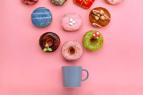पेस्टल गुलाब पृष्ठभूमि पर आइसिंग और कॉफी कप के साथ रंगीन डोनट। मीठे डोनट . — स्टॉक फ़ोटो, इमेज