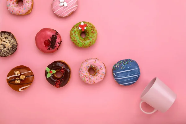 Красочные пончики с глазурью и чашки кофе на фоне пастельной розы. Сладкие пончики . — стоковое фото