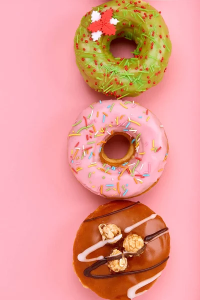 Multi-colored donuts on a pink background folded into a geometric shape. — Stock Photo, Image