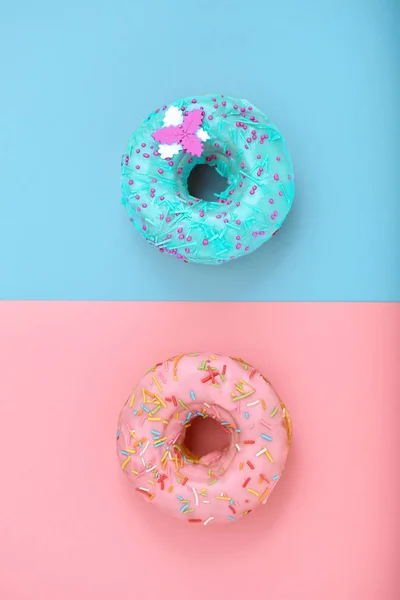 Sweet donuts, blue on pink, pink on blue. Concept conflict of contradictions, individuality in the generalization, the game of color, desserts. Copy space, blue and pink backgrounds