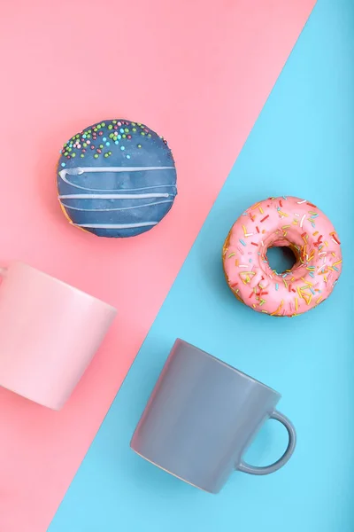 Sweet donuts pink and blue with a mug of coffee. Blue and pink background, game of colors, color conflict. Mock up for design. Copy space. — Stock Photo, Image