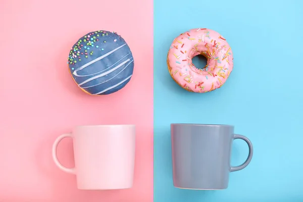 Süße Donuts rosa und blau mit einer Tasse Kaffee. blauer und pinkfarbener Hintergrund, Farbenspiel, Farbkonflikt. mock up für Design. Kopierraum. — Stockfoto