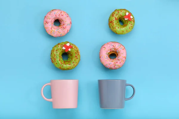 Une tasse à partir de laquelle des beignets sucrés volent, sur un fond bleu. Doux et café beignets concept. couleur sur bleu. Maquette pour le design. Espace de copie . — Photo