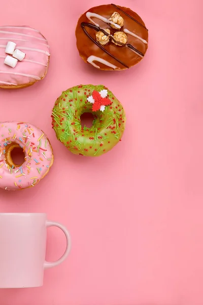 Ein Becher, aus dem süße Donuts auf rosa Hintergrund herausfliegen. Süßigkeiten und Kaffee Donuts Konzept. farbig auf rosa. mock up für Design. Kopierraum. — Stockfoto