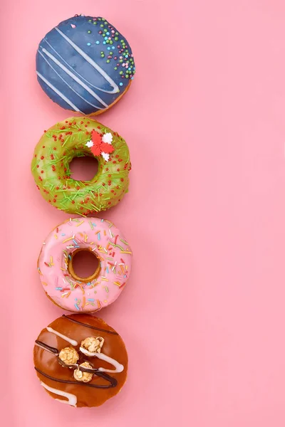 Sweet donuts of different colors, on a pink background. Copy space, blue and pink backgrounds — Stock Photo, Image