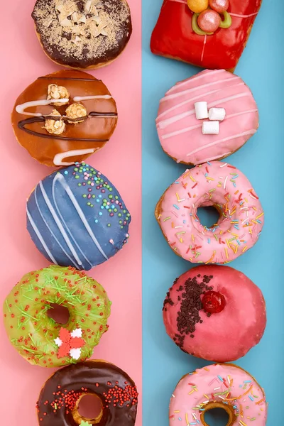 Rosquillas dulces sobre un fondo azul y rosa. Donuts surtidos, borde color azul rosa fondo . — Foto de Stock