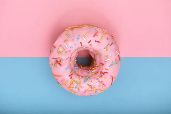 Rosa Donut auf rosa-blauem Hintergrund, Minimalismus-Konzept, Farbspiel. rosa t blauer Hintergrund, Kopierraum, aufgenommen von oben. Unterschiedliches Aussehen einer Einheit. — Stockfoto