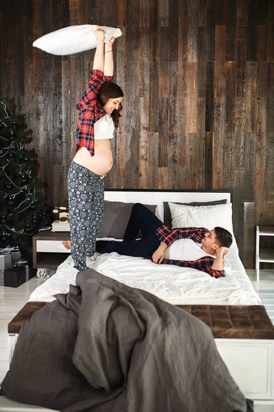 A young married couple awaiting a baby. Beautiful couple lying in the bedroom make plans for the birth of a baby. First child, postpartum, young family.