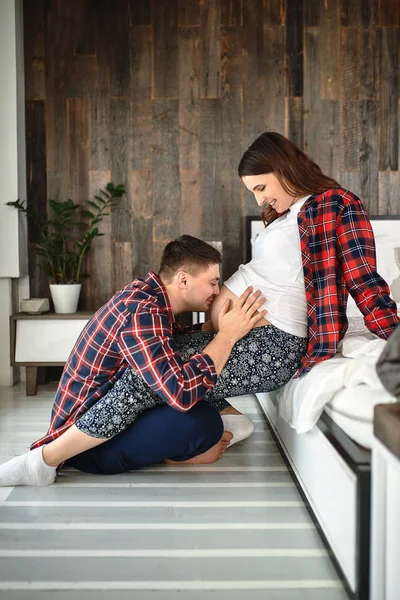 Una joven pareja casada esperando un bebé. Hermosa pareja acostada en el dormitorio hacer planes para el nacimiento de un bebé. Primer hijo, posparto, familia joven . — Foto de Stock