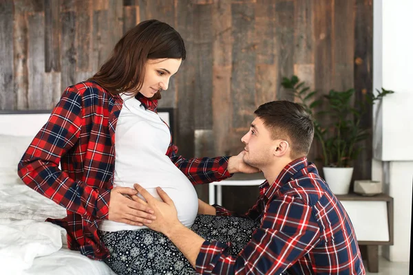Hermosa pareja embarazada en el dormitorio. Preparándose para el parto, padres felices, esperando al primer hijo. Apoyo a las mujeres antes del parto . — Foto de Stock