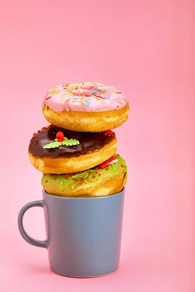 Colorful donuts breakfast composition with different color styles of donuts and fresh coffee on pink background — Stock Photo, Image