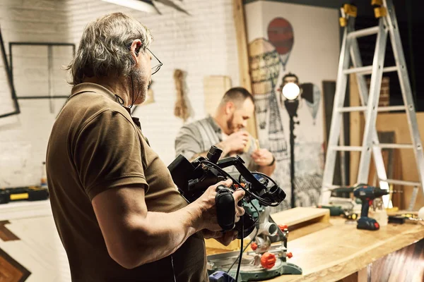 Video production backstage. Behind the scenes of creating video content, a professional team of cameramen with a director filming commercial ads. Video content creation, video creation industry. — Stock Photo, Image