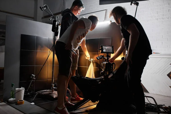 Video production backstage. Behind the scenes of creating video content, a professional team of cameramen with a director filming commercial ads. Video content creation, video creation industry. Low — Stock Photo, Image