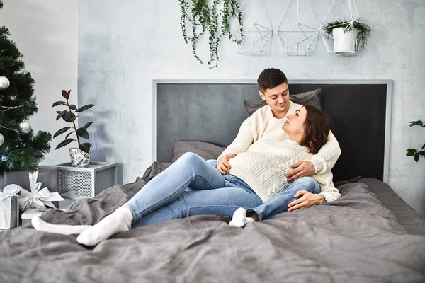 Feliz familia embarazada se encuentra en la cama de la casa. — Foto de Stock