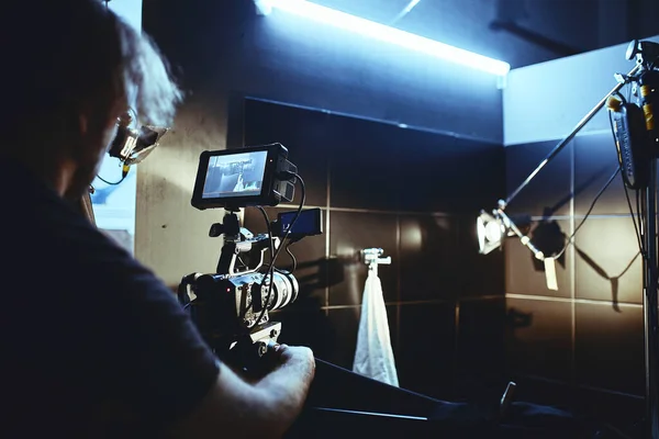 Video production backstage. Behind the scenes of creating video content, a professional team of cameramen with a director filming commercial ads. Video content creation, video creation industry. Low — Stock Photo, Image