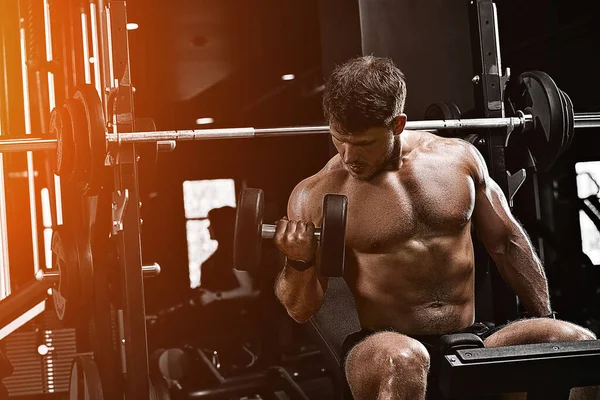 Musculoso culturista chico haciendo ejercicios con pesas en el gimnasio. Cuerpo atlético, estilo de vida saludable, motivación física, cuerpo positivo . — Foto de Stock