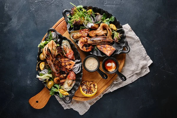 Plato de mariscos a la parrilla. Surtido de deliciosos mariscos a la parrilla con verduras. Bastardos mixtos a la parrilla con salsa de pimienta y verduras. Fondo azul — Foto de Stock