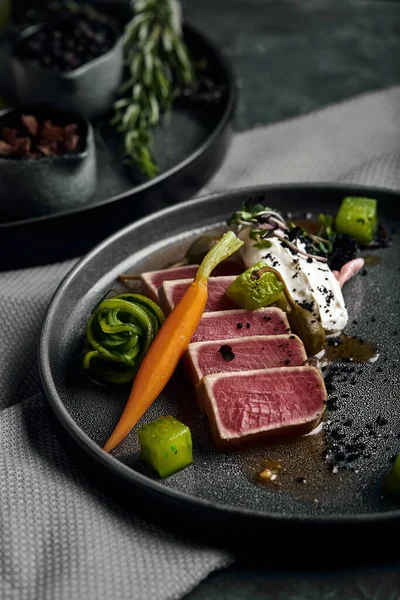 Tuna tagliata in vegetables stewed carrots and peppers, Beautiful serving, traditional Italian cuisine, gray background, copy space. food concept — Stock Photo, Image