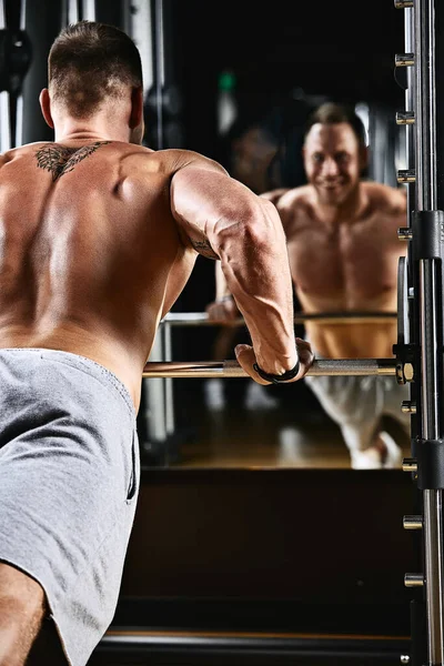 Ein Mann trainiert seine Arme und Brust im Fitnessstudio am Simulator, macht Übungen für verschiedene Muskelgruppen. Findet Motivation, sportlichen Lebensstil, Gesundheit, athletischen Körper, Körper positiv. Filmkorn — Stockfoto