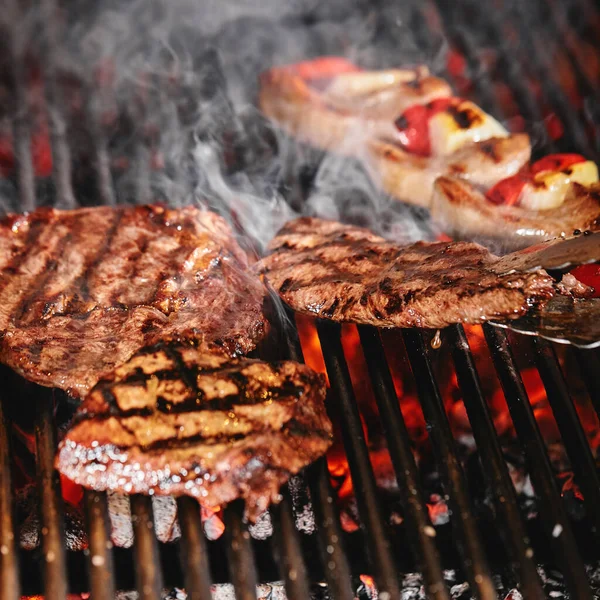 Saftige Beef Steak Flips in einer Grillflamme, Lebensstil, Essen Foto, Kopierraum lizenzfreie Stockfotos
