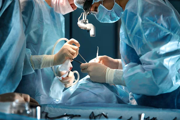 Cerrahların elleri ameliyathanede bir ameliyat aleti tutuyor. Yakın plan, güzel ışık, modern tıp, hayat kurtarmak.. — Stok fotoğraf