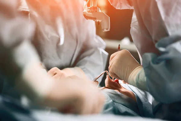 En el quirófano del hospital. Un equipo internacional de cirujanos y asistentes profesionales trabaja en un moderno quirófano. Médicos profesionales celebran vidas salvadas con éxito . — Foto de Stock