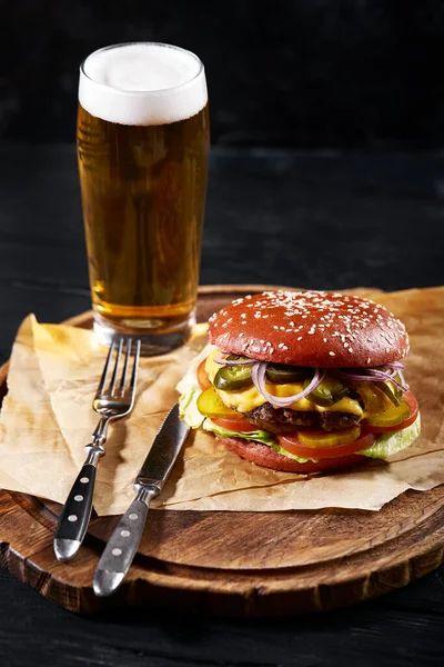 Sada hamburgerového piva a hranolek. Standardní sada nápojů a jídel v hospodě, pivo a občerstvení. Tmavé pozadí, fast food. Tradiční americké jídlo. — Stock fotografie