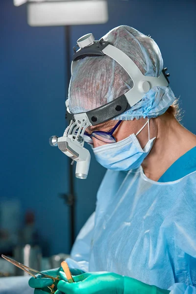 Retrato de cerca de la doctora cirujana usando máscara protectora y sombrero durante la operación. Salud, educación médica, concepto de cirugía . —  Fotos de Stock