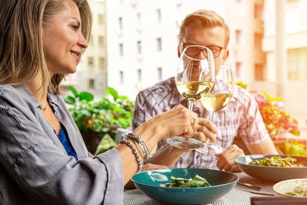 Happy lovers, attractive woman and man enjoy the romance. Attractive couple making selfie, smiling and having fun together. A couple eating salads, drinking wine with taking photos.
