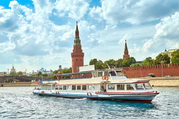 Een modern rivierschip in het centrum van Moskou vaart langs het Kremlin. Schilderachtige moderne stedelijke architectuur. Toerisme, rust in de stad, riviertransport. — Stockfoto