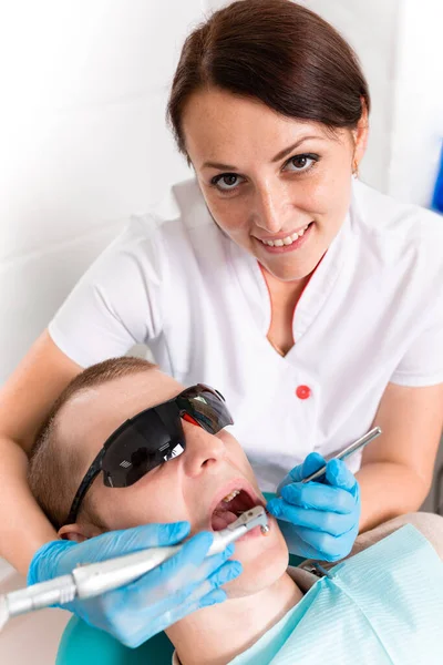 Zahnmedizin, Zahnarzt behandelt einem männlichen Patienten einen Zahn. Karies entfernen, Füllungen auf den Zähnen anbringen. — Stockfoto