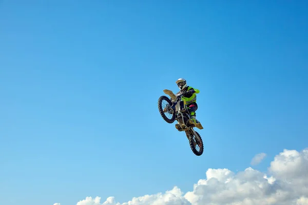 Biker does the trick and jumps in the air. Extreme concept, adrenaline. Copy space. Sky background