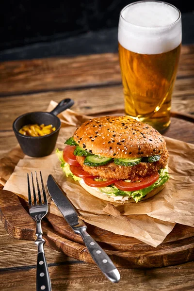 Šťavnatý burger, hranolky, omáčky a sklenici studeného piva na tmavém dřevěném pozadí. kopírovat prostor, fast food set, foto jídla — Stock fotografie