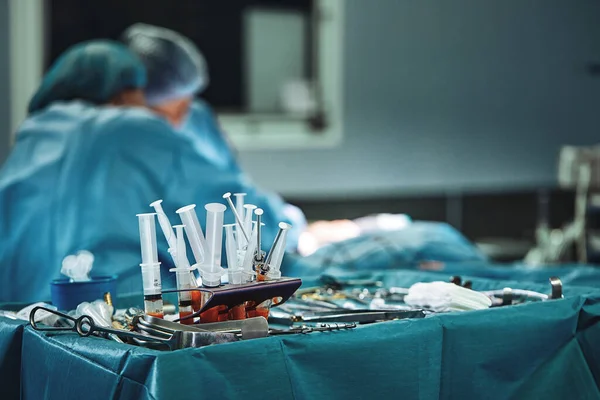 Chirurgische Instrumente im Operationssaal, auf einem sterilen Tisch auf einem speziellen blauen Gewebe ausgelegt. Das Konzept der Medizin, Chirurgie, sterilen Bereich. Plastische Chirurgie. Selektiver Fokus. — Stockfoto