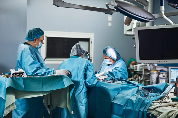 Surgical team operating on patient in theater in hospital