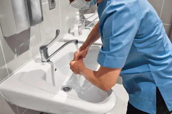 Close-up of a doctor washing his hands using a disinfectant dispenser. — Stock Photo, Image