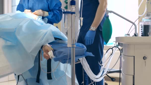 Close-up de um ventilador durante uma operação, 4k tiro. O movimento é lembrado pela ventilação pulmonar artificial, em meio a uma enfermaria com um paciente e médicos. Pneumonia e tuberculose, Covid 19 — Vídeo de Stock