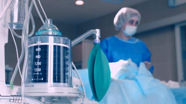 Zbliżenie respiratora podczas operacji, strzał 4k. Ruch jest zapamiętany przez sztuczną wentylację płuc, pośród oddziału z pacjentem i lekarzami. Zapalenie płuc i gruźlica, Covid 19 — Wideo stockowe