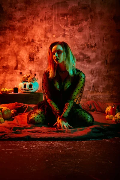 Close up retrato de bela bruxa sexy com maquiagem halloween. pintura de rosto vermelho e preto . — Fotografia de Stock