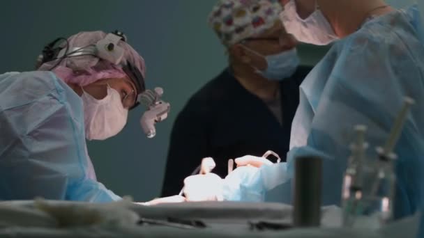 Close-up van de chirurg. Artsen en assistenten werken in de operatiekamer. Chirurgische team en honing verpleegkundige tijdens een echte operatie in een moderne operatiekamer, 4k — Stockvideo