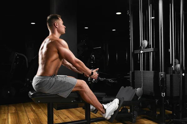 Formda ve kaslı bir adam göğüs kaslarını jimnastik salonunda blok simülatöründe çalıştırıyor. Spor salonunda eğitilmiş ideal bir fitness modeli. Spor afişi, kopyalama alanı, fitness motivasyonu. — Stok fotoğraf