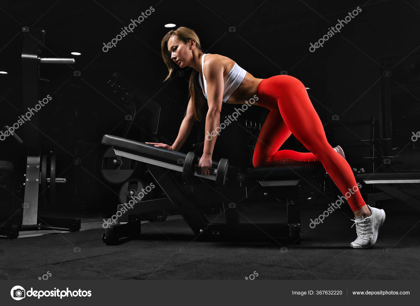 Bodybuilder girl posing on camera with dumbbells in the gym. Fitness  motivation, movement of life, towards a goal through pain, sweat, blood and  tears. Copy space, dark background. Stock Photo by ©Gerain0812