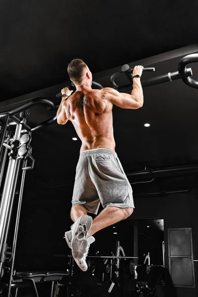 Bodybuilder macht Klimmzüge. Muskelprotz in der Turnhalle. Vorbereitung auf Wettkämpfe, Funktionstraining. Der Athlet findet zu seiner Form. — Stockfoto