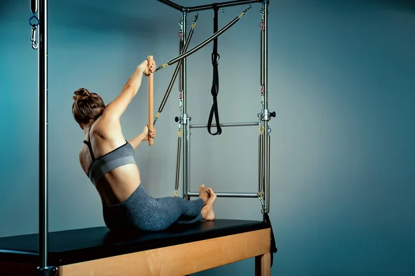 Pilates reformer bed, close-up, woman and instructor doing exercise on reformer simulator for treatment of musculoskeletal system. — Stock Photo, Image