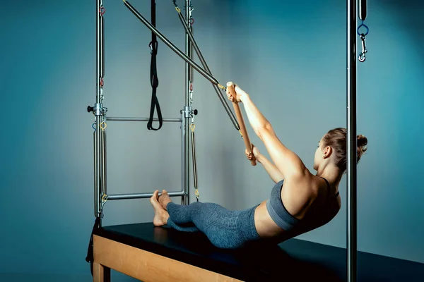 Pilates reformer bed, close-up, woman and instructor doing exercise on reformer simulator for treatment of musculoskeletal system. — Stock Photo, Image
