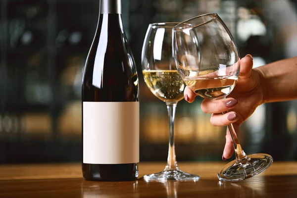 Melayani dengan gelas anggur dan botol di atas meja, tangan mengangkat segelas anggur, Konsep minum anggur. Salin ruang — Stok Foto
